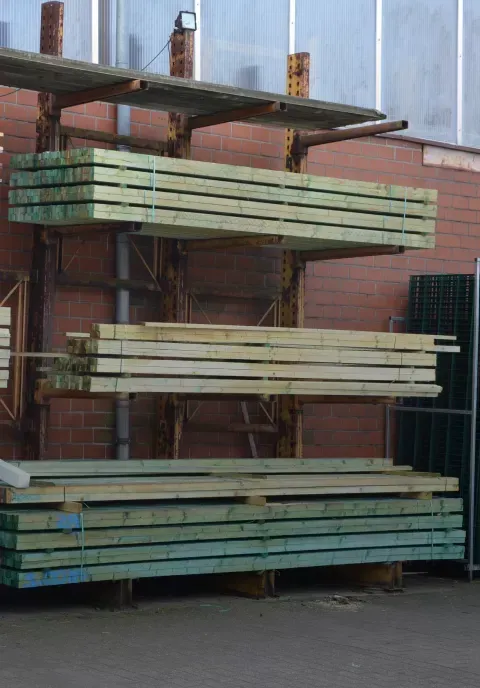 Ein Bündel Holz auf einem Gestell vor einem Gebäude gestapelt