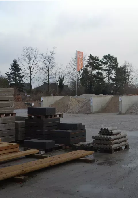 Ein großer Stapel Holz liegt auf einem Parkplatz