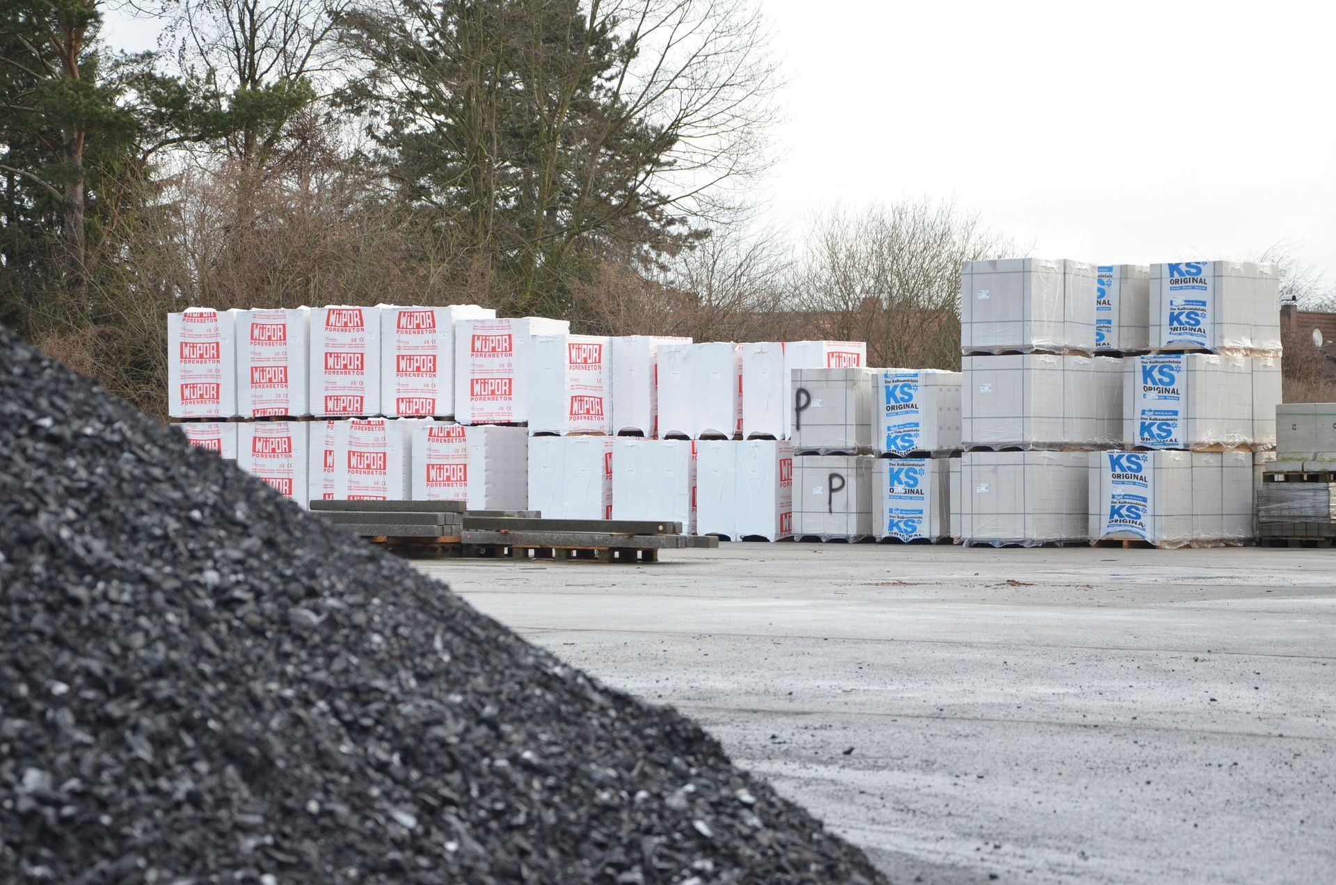 Ein Haufen Kohle liegt neben einem Haufen Ziegelsteine.