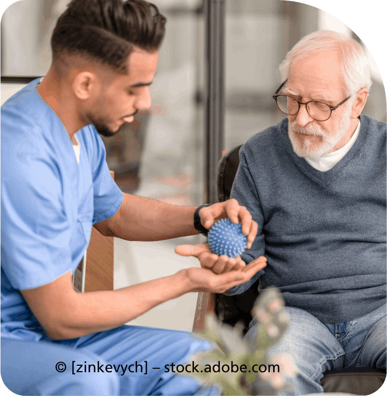 Ein Krankenpfleger hilft einem älteren Mann mit einem Ball.