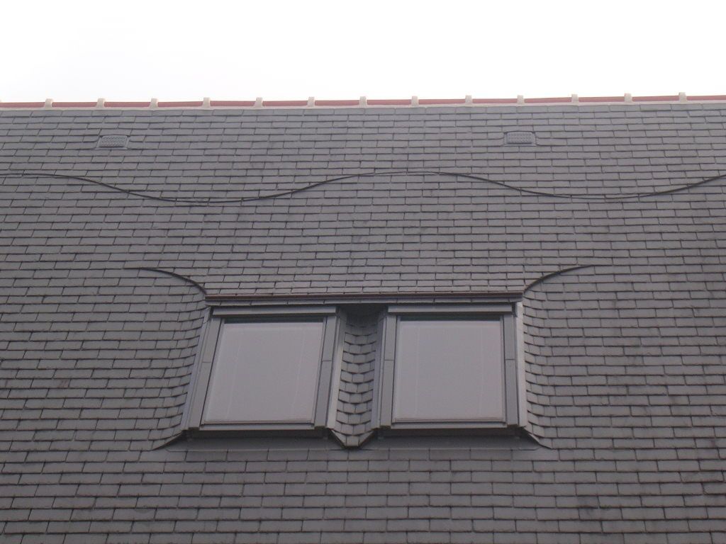 Deux fenêtres de toit installées sur une couverture en ardoise
