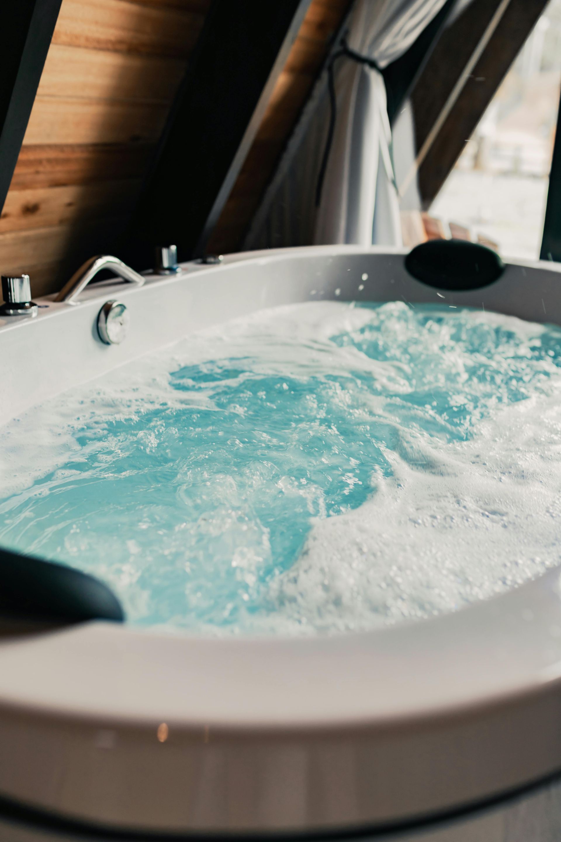 Agua azul burbujeante en una bañera de hidromasaje blanca.