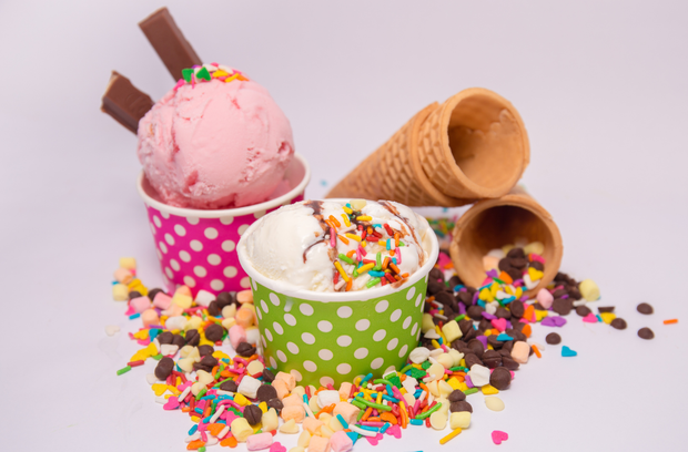 Due coppe di gelato circondate da granella e coni