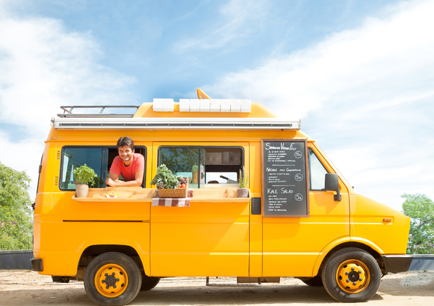 Un camioncino giallo con un uomo dietro il bancone