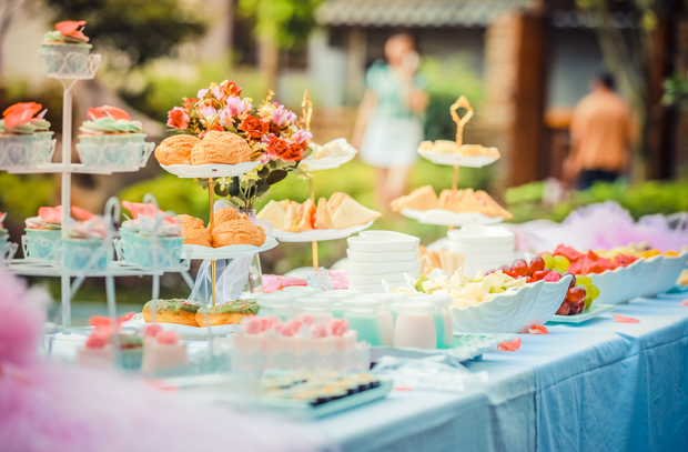 Un tavolo con un sacco di cibo sopra, compresi cupcake e frutta