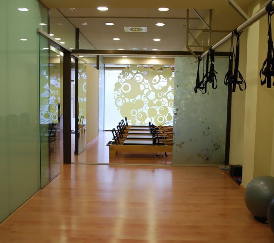 Una fila de máquinas de pilates están alineadas en un gimnasio.