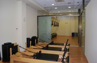 Una fila de máquinas de pilates están alineadas en un gimnasio.