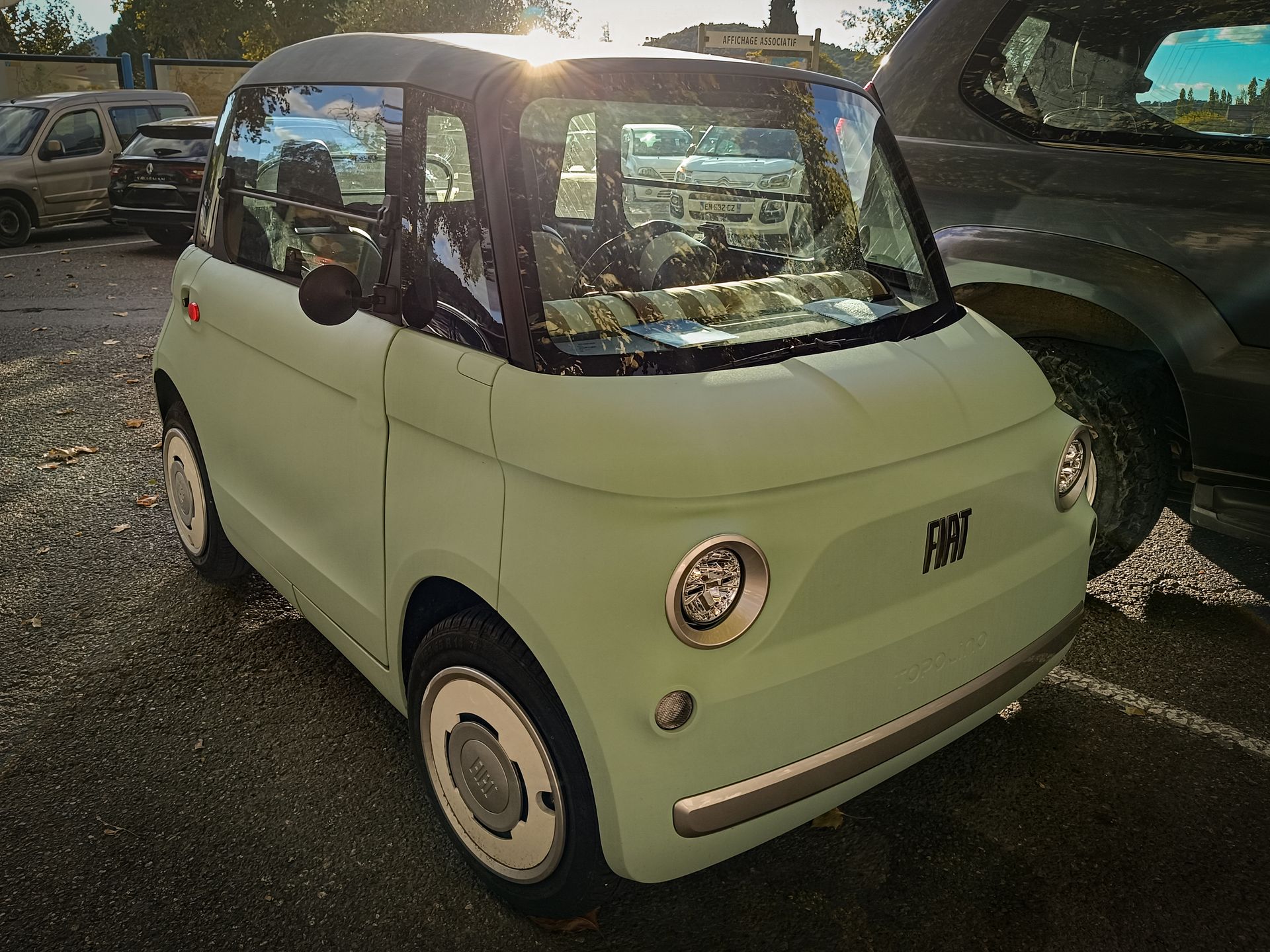 Une Fiat Topolino compacte vert clair garée à l'extérieur.