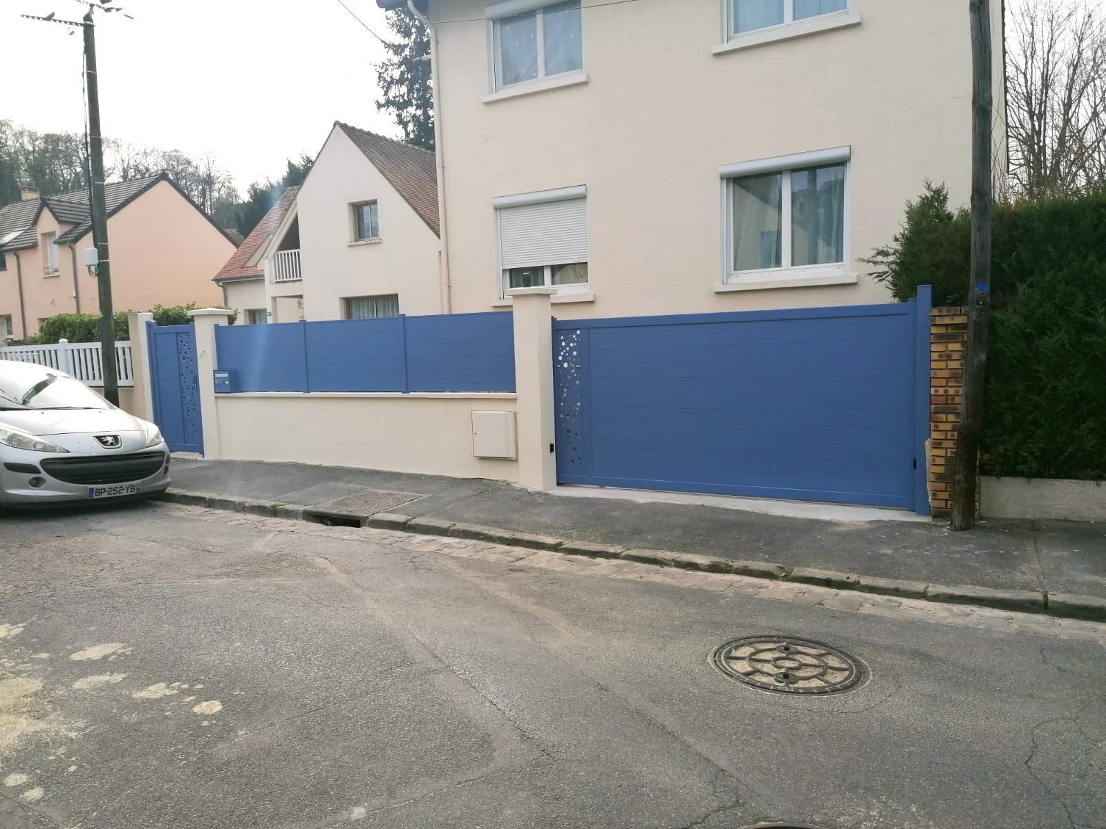 Portail, portillon et clôture bleus devant une maison