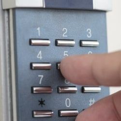 Personne tapant un code sur un dispositif d'alarme