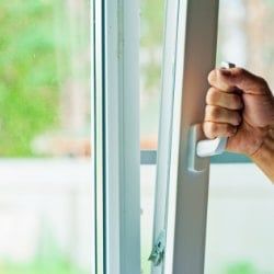 Personne fermant une fenêtre oscillobattante