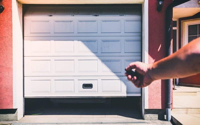 Personne ouvrant une porte de garage sectionnelle