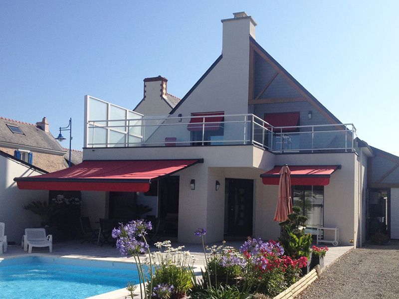 Maison avec piscine et stores bannes rouges