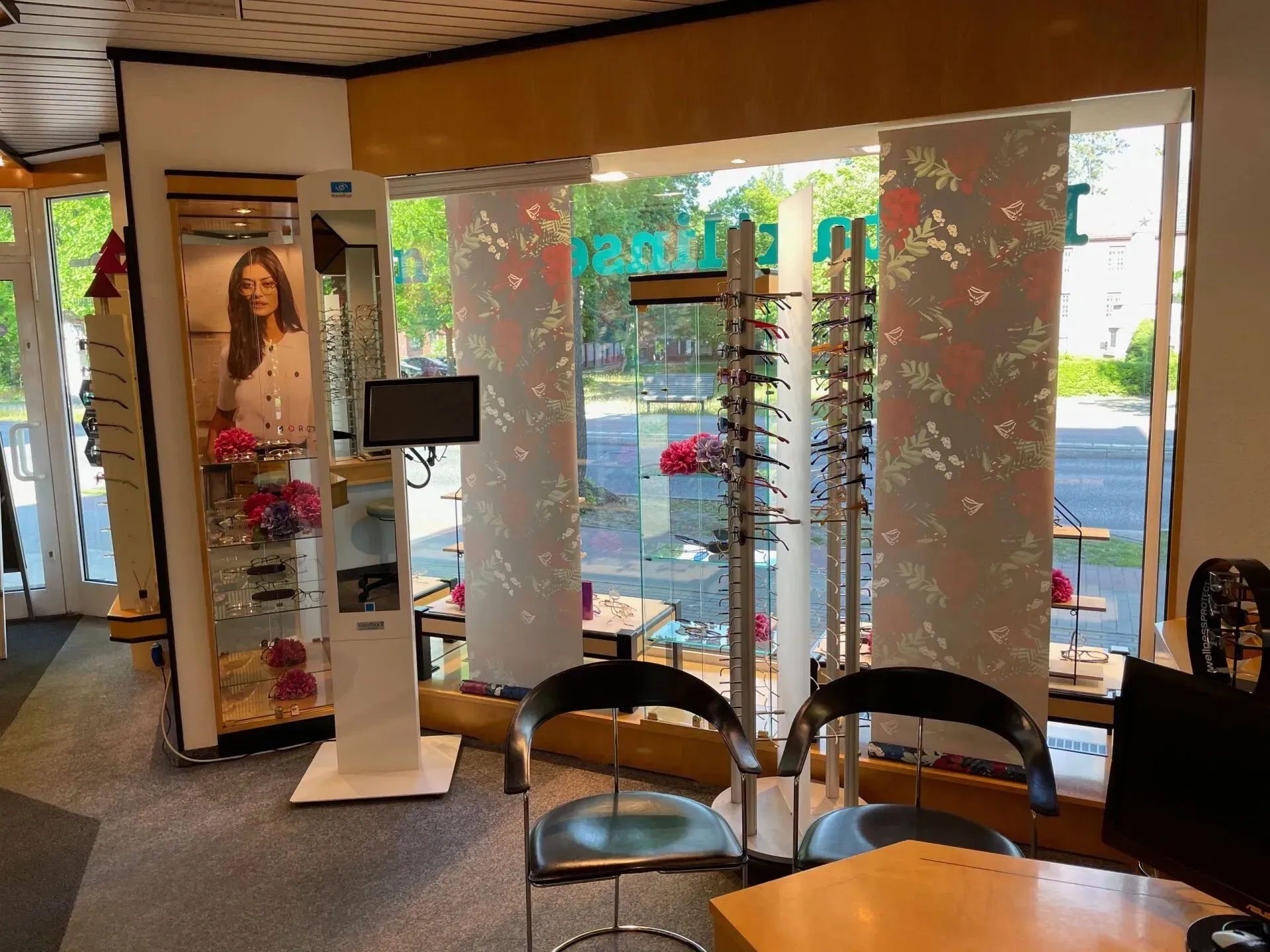 Geschäftsräume von Optik Bolle mit Brillenauslagen, Stühlen und einem großen Schaufenster mit Blick auf die Straße