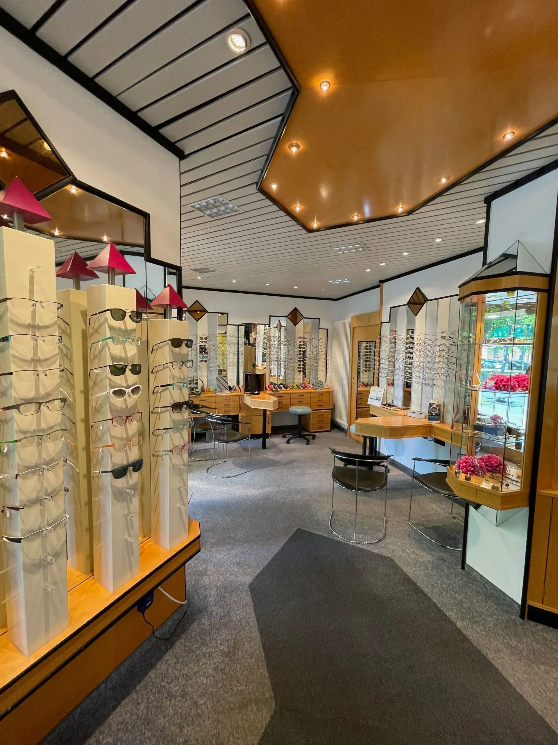 Innenansicht unseres Optikergeschäfts mit Brillenauslagen und Wartebereich.