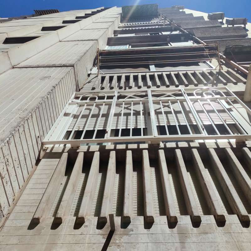 Mirando hacia arriba a un edificio alto con una escalera de incendios