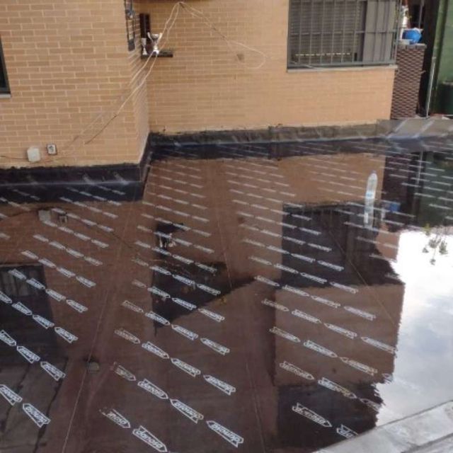 Un edificio de ladrillo se refleja en un charco de agua.