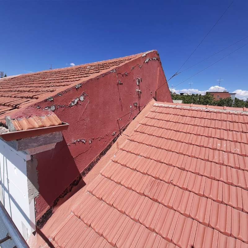 Un techo de tejas rojas con un cielo azul al fondo