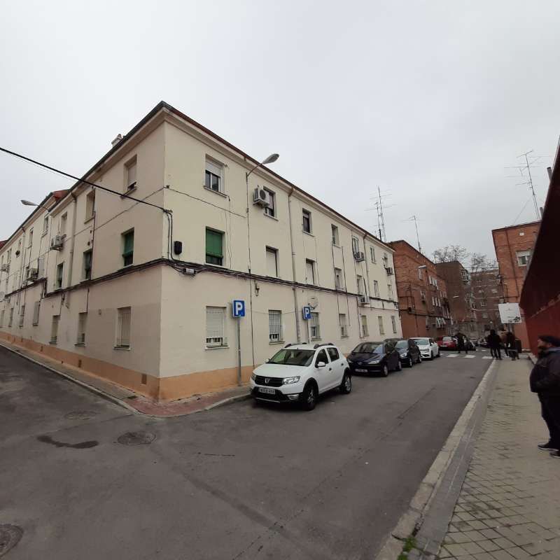 Una camioneta blanca está estacionada frente a un gran edificio.