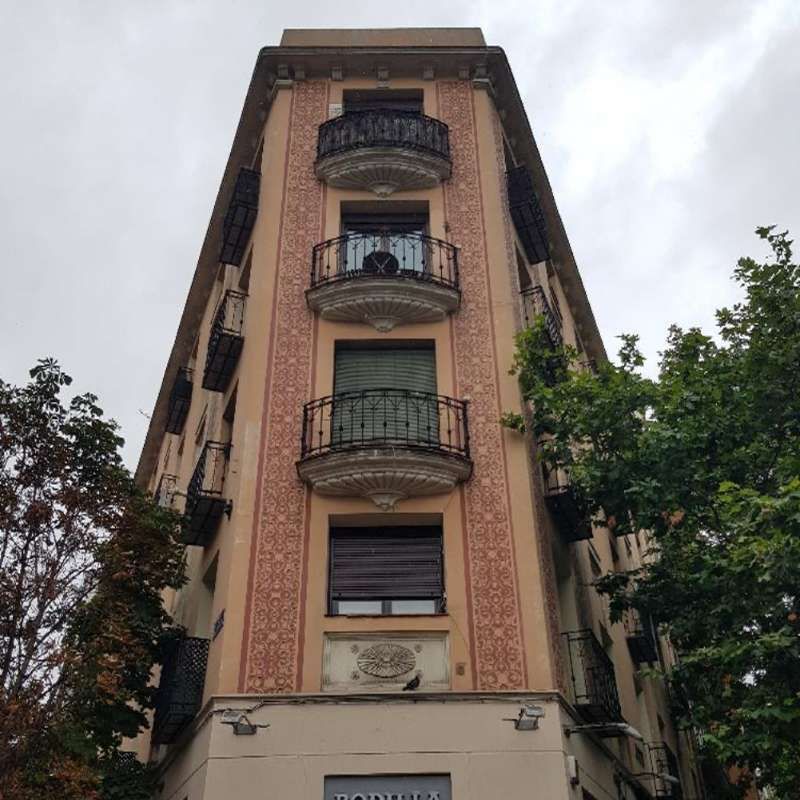 Un edificio alto con un balcón y un cartel que dice 'a' en él.
