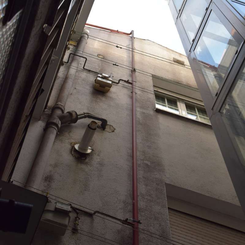 Mirando hacia arriba a un edificio con muchos cables y tuberías