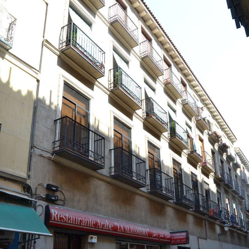 Un edificio con balcones y un cartel de restaurante.