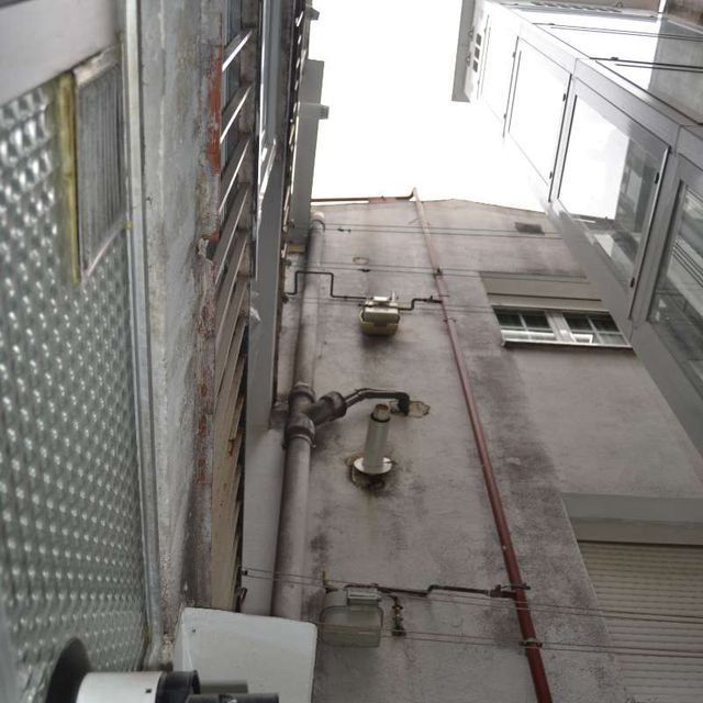 Un edificio muy alto con muchas ventanas y tuberías.