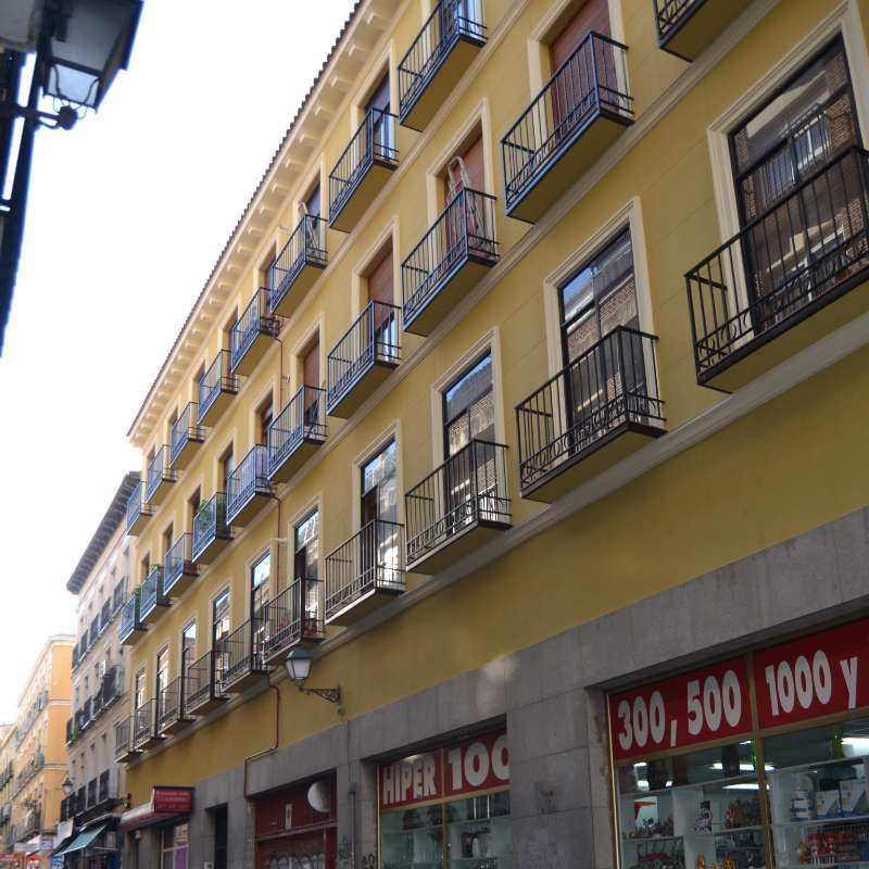 Un edificio amarillo con balcones y un cartel que dice 300 500 1000