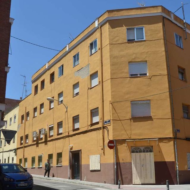 Un edificio amarillo con una señal de stop delante.