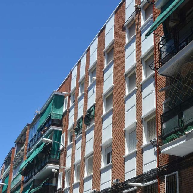 Un edificio de ladrillo con muchas ventanas y balcones.
