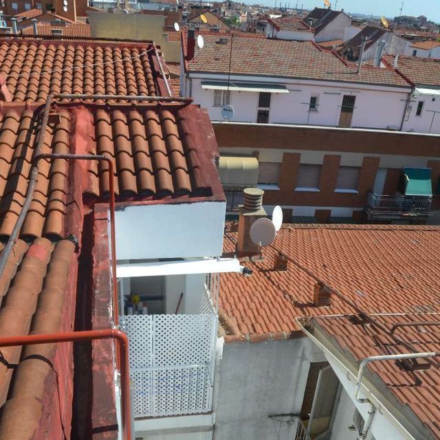 Una vista de la azotea de una ciudad con balcón y antenas parabólicas.