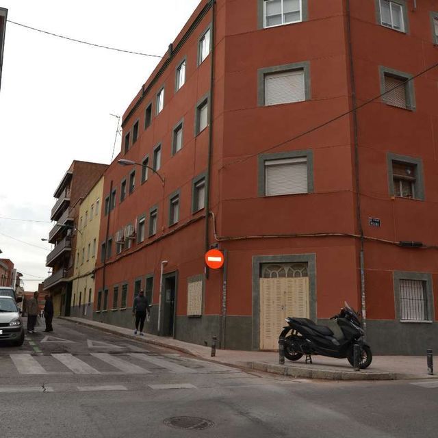 Un scooter está estacionado frente a un edificio con una señal de prohibido el paso.