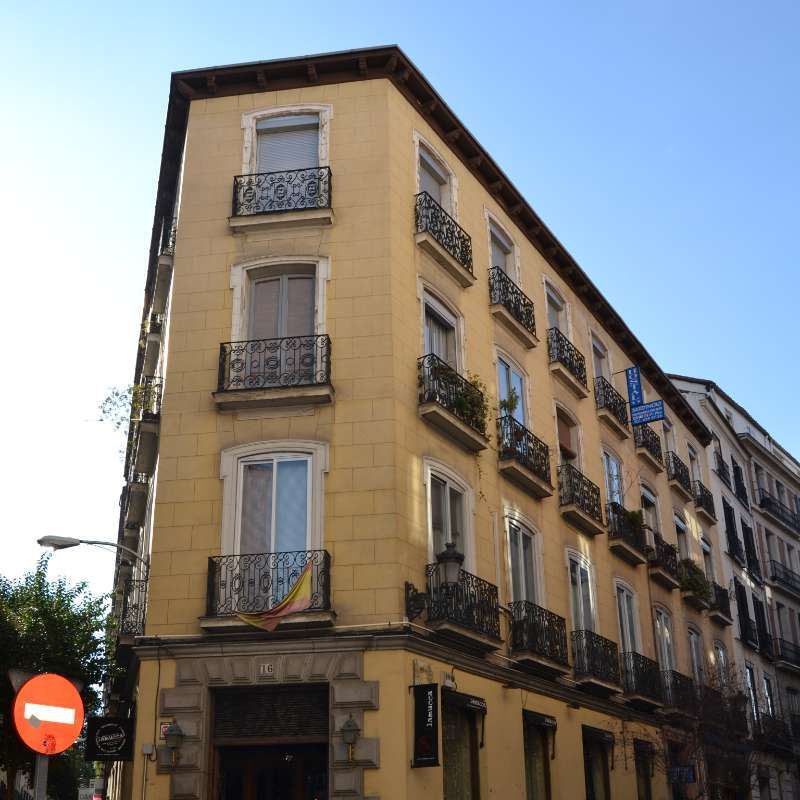 Un edificio amarillo con balcones y una señal de no entrar.