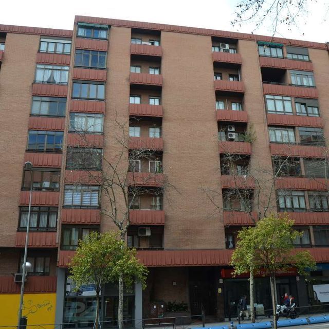 Un gran edificio de ladrillo con muchas ventanas y balcones.