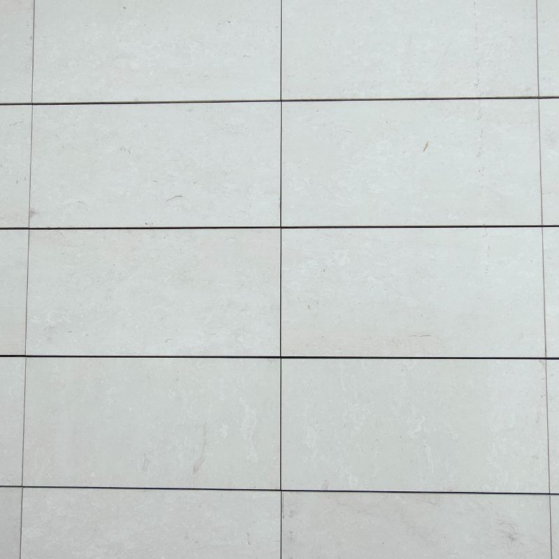 Un primer plano de un piso de baldosas blancas con un patrón de cuadrícula.