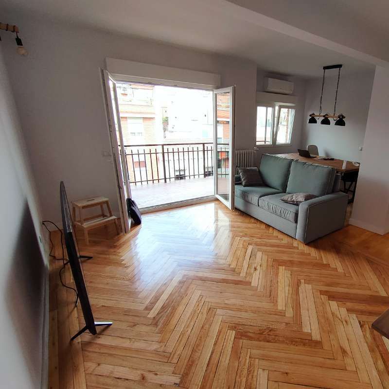 Una sala de estar con un sofá y un televisor de pantalla plana.