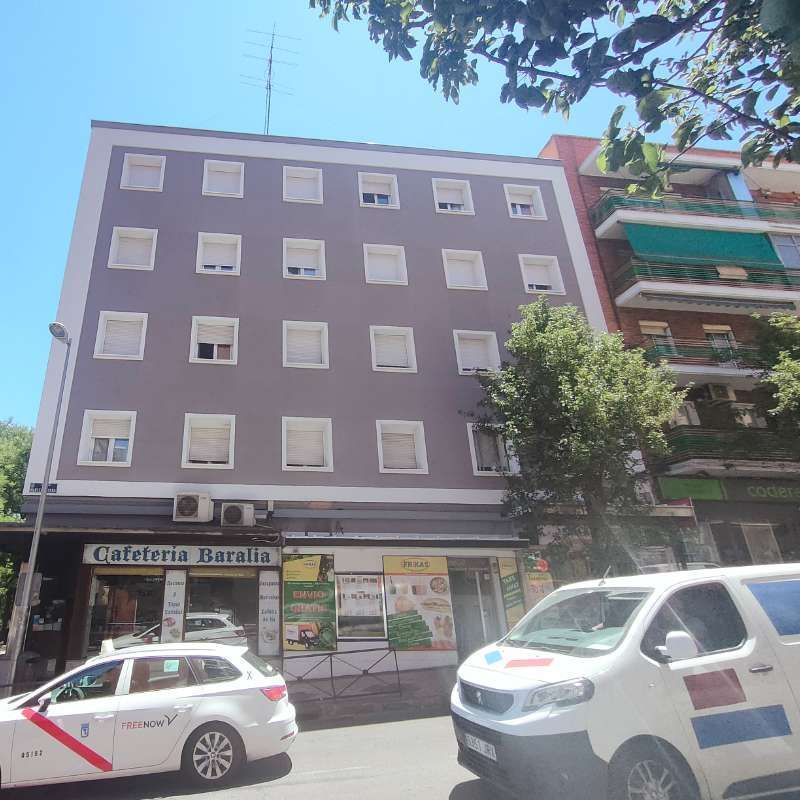 Dos coches están aparcados delante de la cafetería seralia