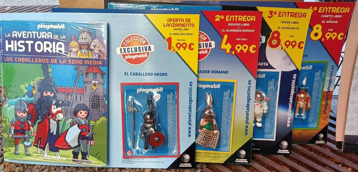 Una colección de juguetes Playmobil están sobre una mesa.