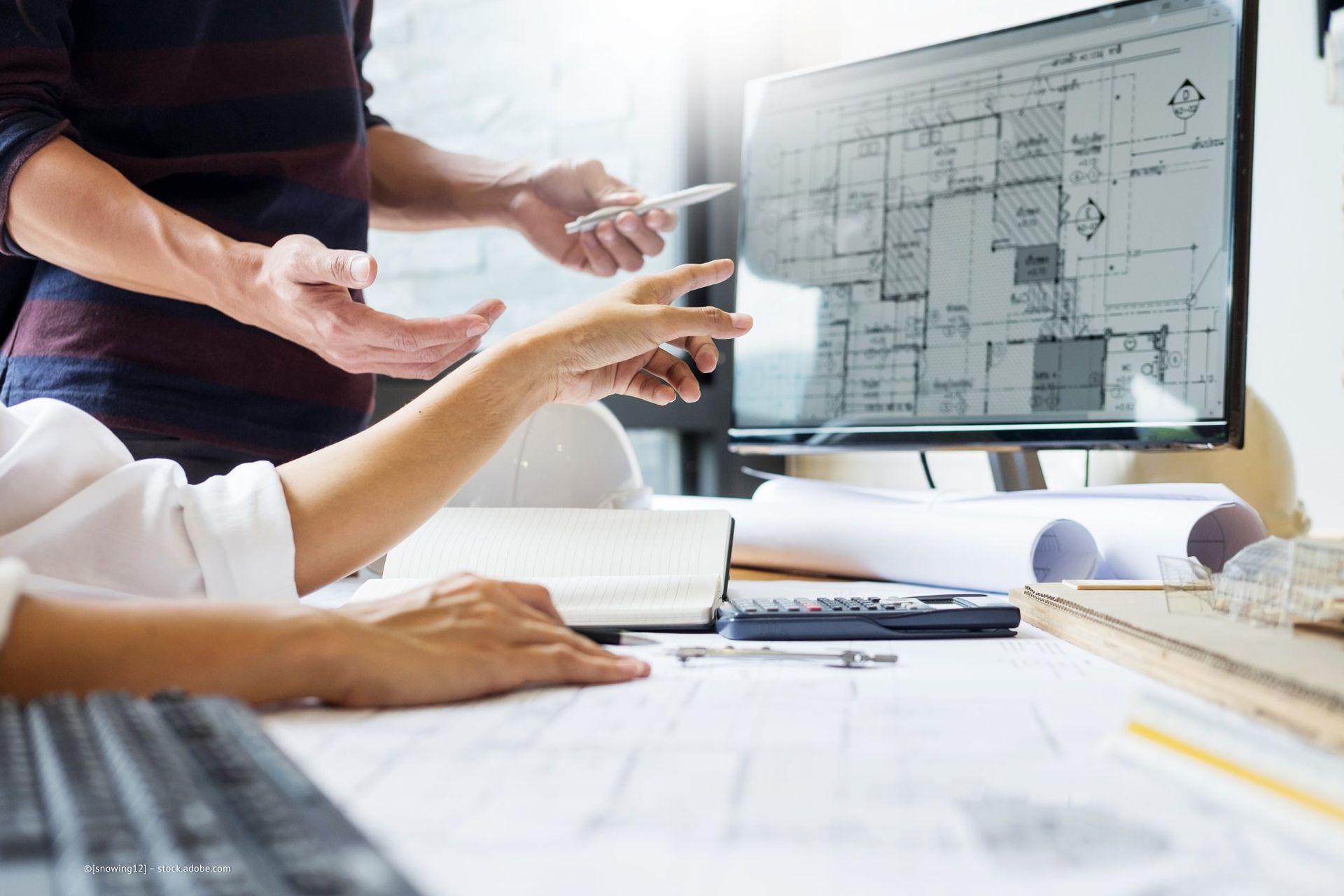 Ingenieure schauen sich einen Bauplan am PC an