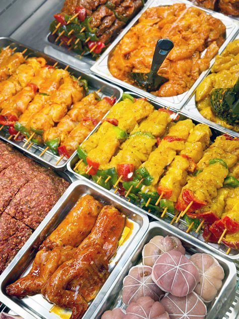 Présentation de différents plats marinés avec plusieurs épices comme brochettes de poulet et de morceaux de poulets marinés, viandes hachées de bœuf aux épices.
