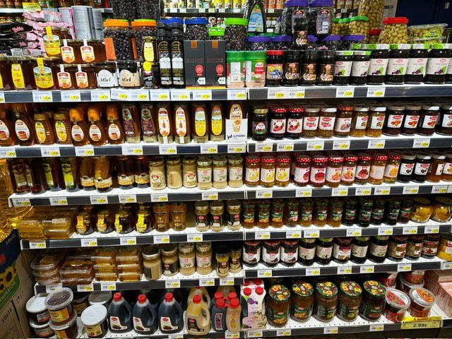 Rayon rempli de pots de confiture, de miel et pots d'olives vertes et noires.