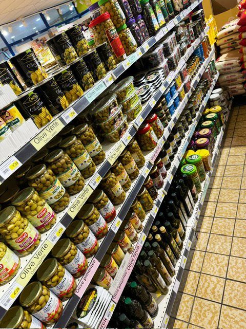 Rayon avec différents pots d'olives vertes et noires et de bouteilles d'huiles d'olive.