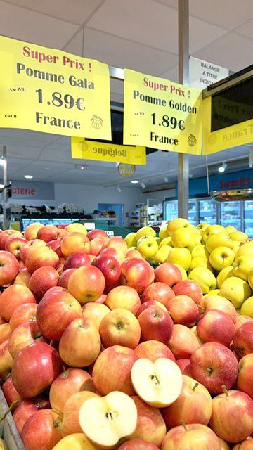 Pommes en vente : pommes Gala (rouges) et Golden (jaunes) sur un étalage.