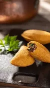Un primer plano de un pastel con un mordisco cortado sobre una mesa.