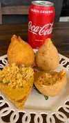 Un plato de comida junto a una lata de Coca Cola