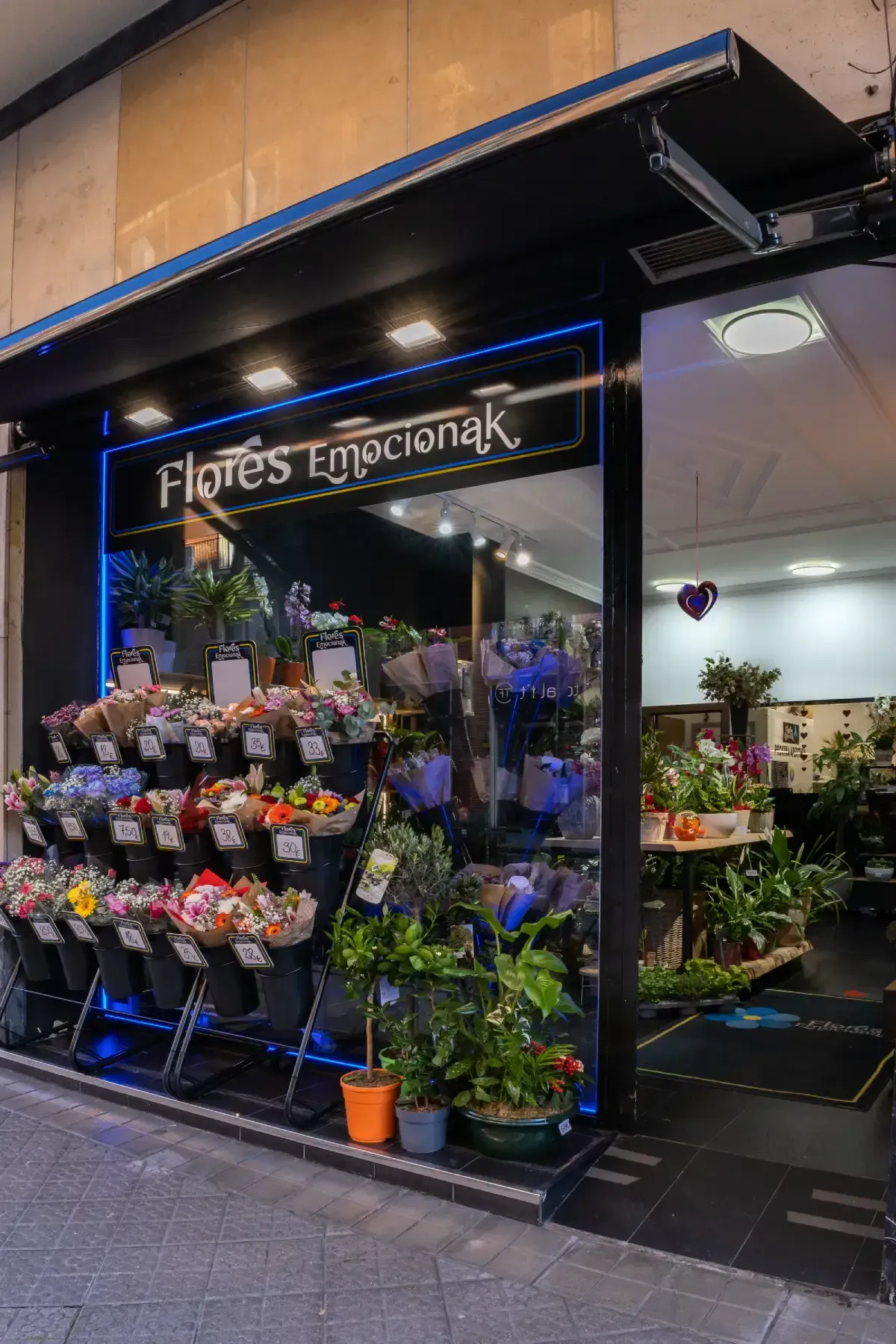Escaparate de floristería con coloridos ramos y plantas en macetas expuestas en el exterior.
