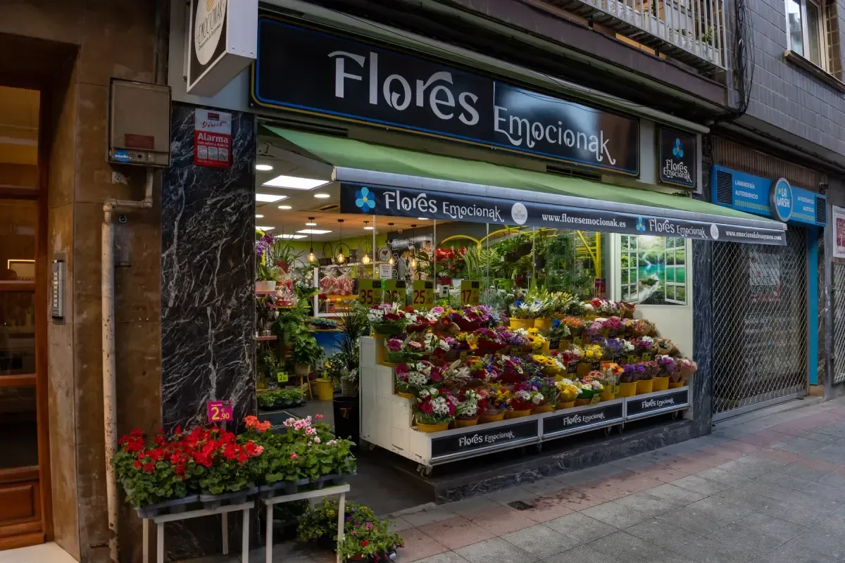 Escaparate de una floristería con coloridos ramos expuestos en la acera de la ciudad.