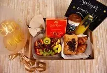 Una caja llena de comida y un globo sobre una mesa.