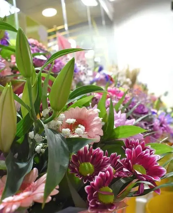 Un ramo de flores rosas y moradas con hojas verdes.