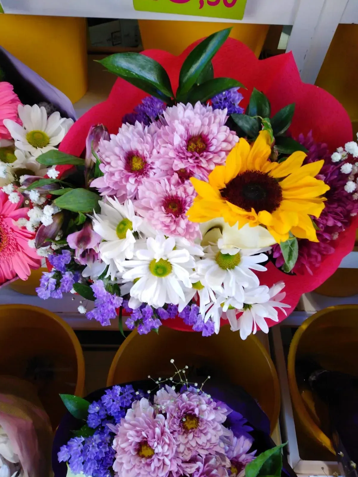 Un ramo de flores con un girasol en el medio.
